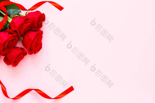 粉色背景上的红玫瑰。<strong>爱</strong>忏悔。情人节的庆祝活动。红玫瑰和彩带，情人节的概念，周年纪念日，<strong>母亲节</strong>和生日问候，复制空间，顶视图.