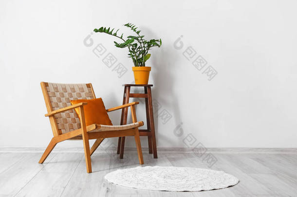 舒适的扶手椅和凳子，室内轻墙附近有<strong>室内盆栽</strong>