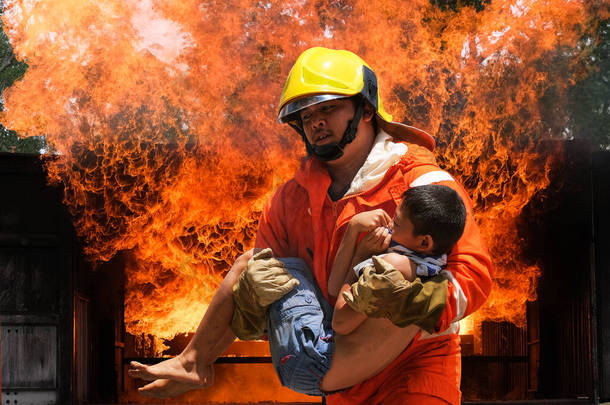 消防队员抱着男孩在火中和烟雾中救活他，消防队员把男孩从火中解救出来.