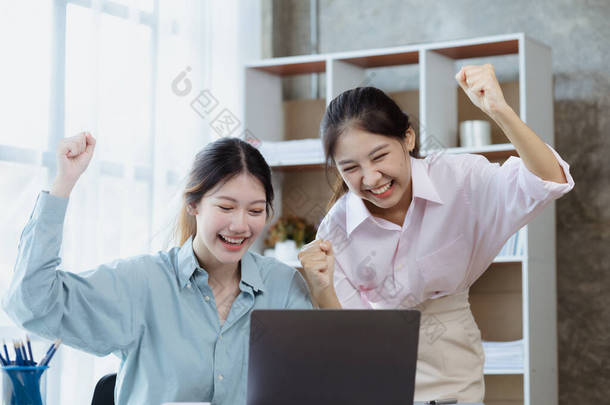 两名女性在笔记本电脑上显示出喜悦和数据，两名商业女性在每月的销售情况总结中超越了销售目标，实现了盈利增长。销售管理概念