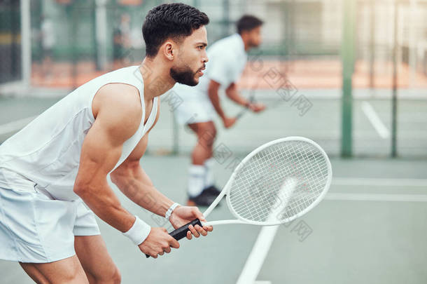 两名民族网球选手手握球拍，准备在法庭上比赛。严肃、专注的运动员站在一起。2.在体育俱乐部里，打双打比赛是为了保持身体降.