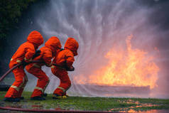 Firefighter Rescue team training in fire fighting extinguisher. Firefighter teamwork fighting with f