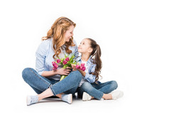 快乐的母亲和小女儿的花束看着彼此孤立的白色, 母亲节的概念