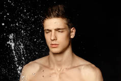 湿裸上身运动的家伙在水飞溅和下降的肖像