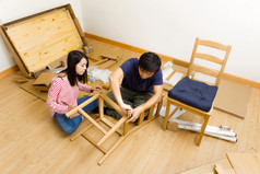组装新房子的家具对亚裔夫妇