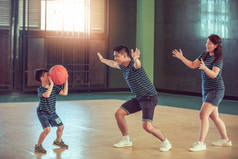 亚洲家庭一起在体育馆打篮球