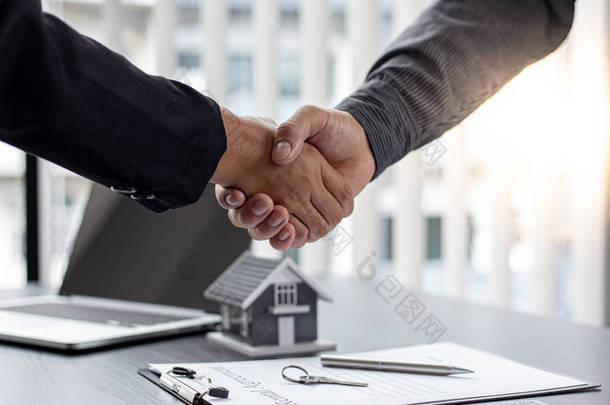 地产经纪人和客户握手祝贺双方签订了土地和保险、握手和良好反应概念的购房合同.