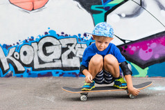 Young Boy Crouching on Skateboard in Skate Park