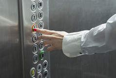 按下按钮，电梯里的女性手