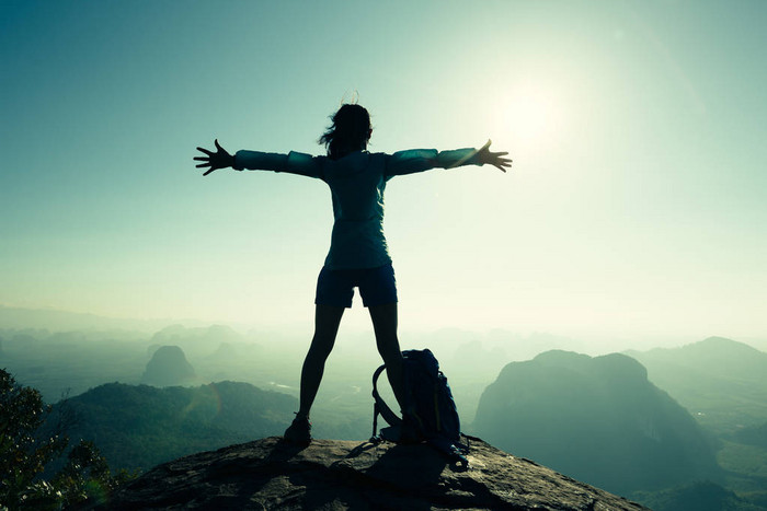 女人站在张开双臂的徒步旅行者