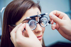 年轻的妇女检查她的视力与眼科医生。医疗设备.