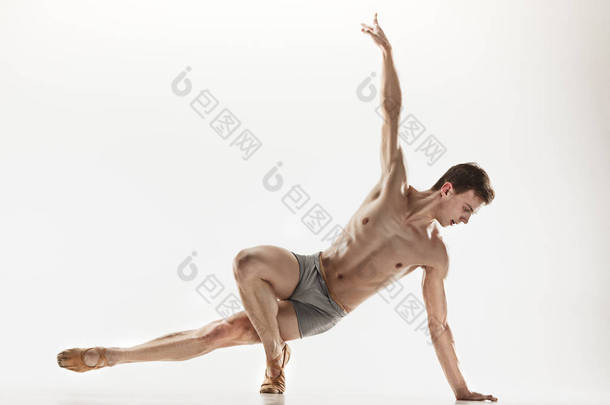 在完<strong>美</strong>的<strong>形</strong>状，在灰色的背景下执行运动的芭蕾舞演员.