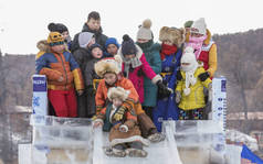Hatgal, 蒙古, 2018年3月4日: 蒙古儿童身着传统服装在冰冻的湖泊 Khuvsgul, 下来的幻灯片 madeout 冰