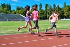 家庭体育和健身, 快乐的母亲和孩子跑在体育场跑道室外, 儿童健康活跃的生活方式概念
