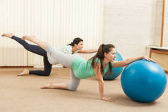美丽的孕妇做瑜伽在健身房的球