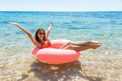 疯狂的游泳与充气甜甜圈在海滩上夏日阳光明媚的一天