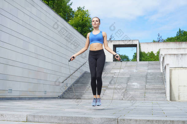 年轻, 适合和运动的女孩跳跳绳跳绳。健身、运动、城市慢跑和健康生活方式概念.