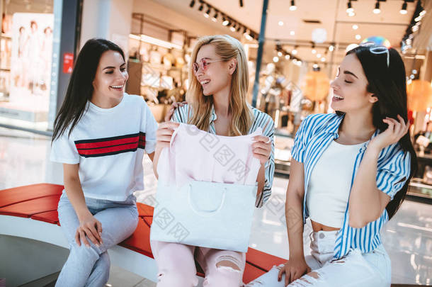 三有吸引力的年轻女孩在现<strong>代购</strong>物中心购物购物袋.