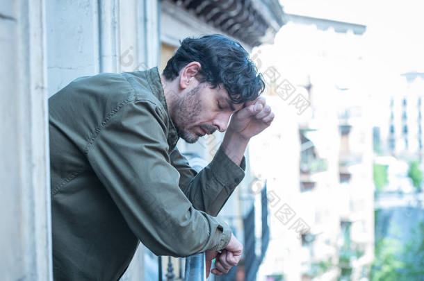 闭上悲伤沮丧的男人的肖像看窗外在家庭中遭受抑郁症和孤独感的心理健康概念