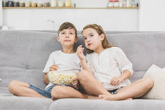 快乐的孩子在家看电影和吃爆米花