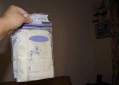 妇女手持有冷冻母乳在存储袋, 母乳喂养概念