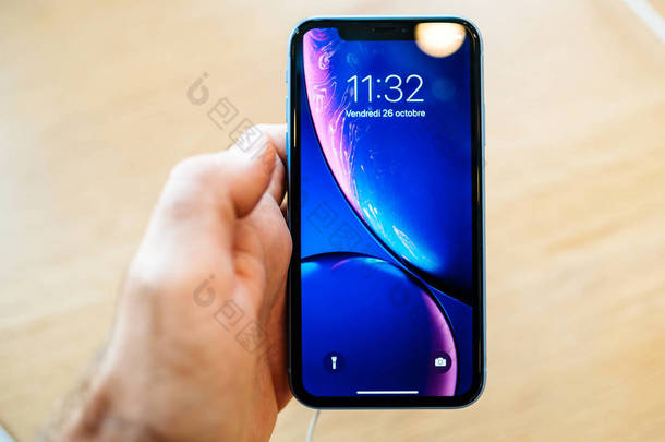 法国巴黎--2018年10月26日: 在新智能<strong>手机</strong>的推出日, 男子手牵着<strong>苹果</strong>商店电脑上最新的蓝色 iphone xr 智能<strong>手机</strong>