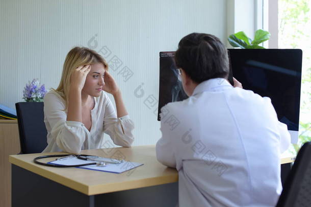 妇女在医院与医生精神科医生交谈, 讨论问题, 并找到解决心理健康问题的办法。患头痛的年轻美女绝望和压力.