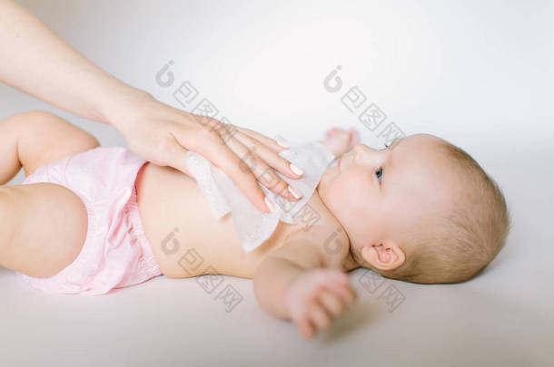 卫生-年轻的妈妈用湿纸巾擦拭婴儿皮肤。清洁擦拭, 纯净, 干净