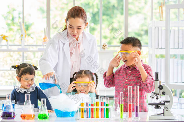 科学<strong>老师</strong>教亚洲学生化学制品, <strong>老师</strong>把化学物质倒进玻璃碗里, 在实验室里把五颜六色的试管和显微镜放在桌子上, 在实验室里学习的概念.