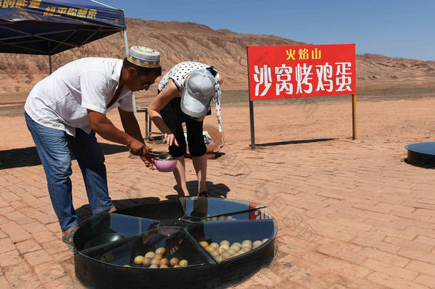 2017年7月9日, 中国西北新疆维吾尔自治区吐鲁番盆地霍岩 (火海) 山脚下的烤蛋旅游商店