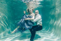 美丽浪漫的情侣轻轻拥抱在水下