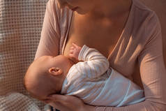 年轻母亲母乳喂养婴儿在夜间的作物拍摄