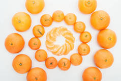 平躺着去皮的橘子片和整个橘子在白色背景上的圆圈
