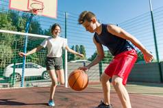 青少年男孩教练他的女朋友打篮球, 街头篮球比赛
