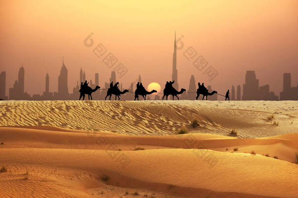 日落时分在<strong>迪拜</strong>天际线下的沙漠中的骆驼<strong>旅游</strong>车队