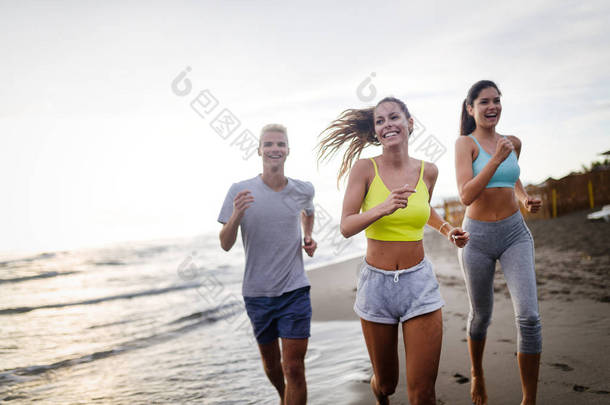 一群运动员在海滨跑步.参加户外运动服装训练的跑步者.