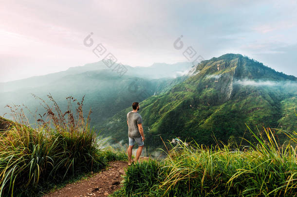 一个人背背在山里。一个人在亚洲旅行。前往斯里兰卡。山里的旅客一个人享有美丽的山景。山中日出的人