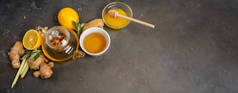 用新鲜生姜、柠檬草、鼠尾草、蜂蜜和柠檬，在深色背景下，用复制空间制作健康的抗氧化剂和抗炎姜茶.