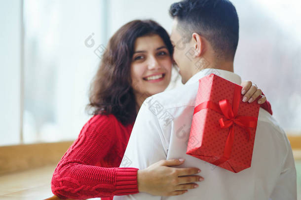 幸福的一对，抱着<strong>礼物</strong>。 红礼<strong>盒</strong>在一对相爱的夫妇手里。 情人节，节日和<strong>惊喜</strong>的概念。 情侣们互赠<strong>礼物</strong>。 关系和爱情概念.