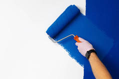 戴手套的男性手绘墙壁变成经典的蓝色