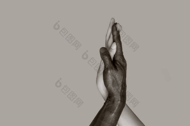 <strong>黑白</strong>照片一种<strong>黑白</strong>照片，其中黑人男女的手触摸手掌，相互交织在一起种族间友谊和尊重的概念。空间复制，灰色孤立的背景