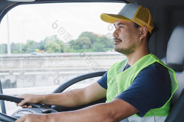 专业的<strong>卡车司机</strong>，自信的中年男子，身穿安全服装，自豪地向前迈进，从事一项长期的运输业务