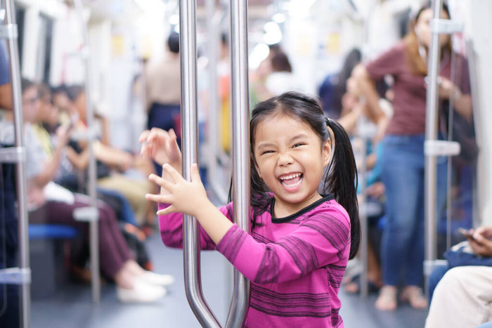 亚洲小孩或小女孩笑着享受乘坐地铁或地铁的