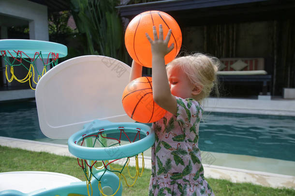 活泼的蹒跚学步的小女孩玩球。孩子们在户外操场上玩耍。儿童健康的夏季<strong>活动</strong>。在学校或<strong>幼儿园</strong>院子里玩耍的孩子.