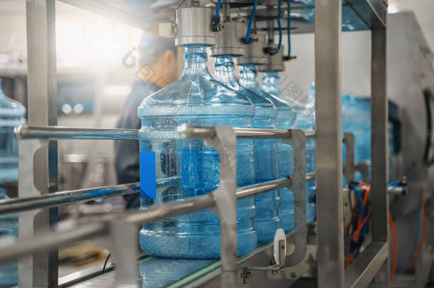 自动输送机生产线上的塑料瓶或加仑。供水厂