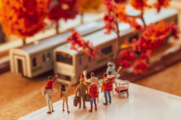 <strong>秋季</strong>或<strong>秋季</strong>在月台上等待或挥动列车的团体过路人的微型玩具雕像- -采用暖色调过滤器.
