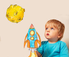 小可爱的蹒跚学步的男孩用纸制宇宙飞船在地球上的火箭土地玩耍，非常专注