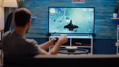 男人用操纵杆在游戏机上玩电子游戏