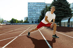 年轻的白人运动员，男性运动员，独自在体育场、运动场或室外跑道上跑步。夏季运动会.
