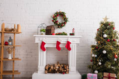有圣诞长袜的壁炉，靠近装饰过的松树和客厅里的木架